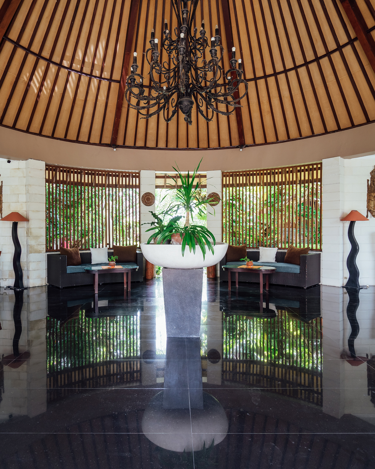 Balinese-style lounge with dark wood furniture at The Bidadari Villas & Spa