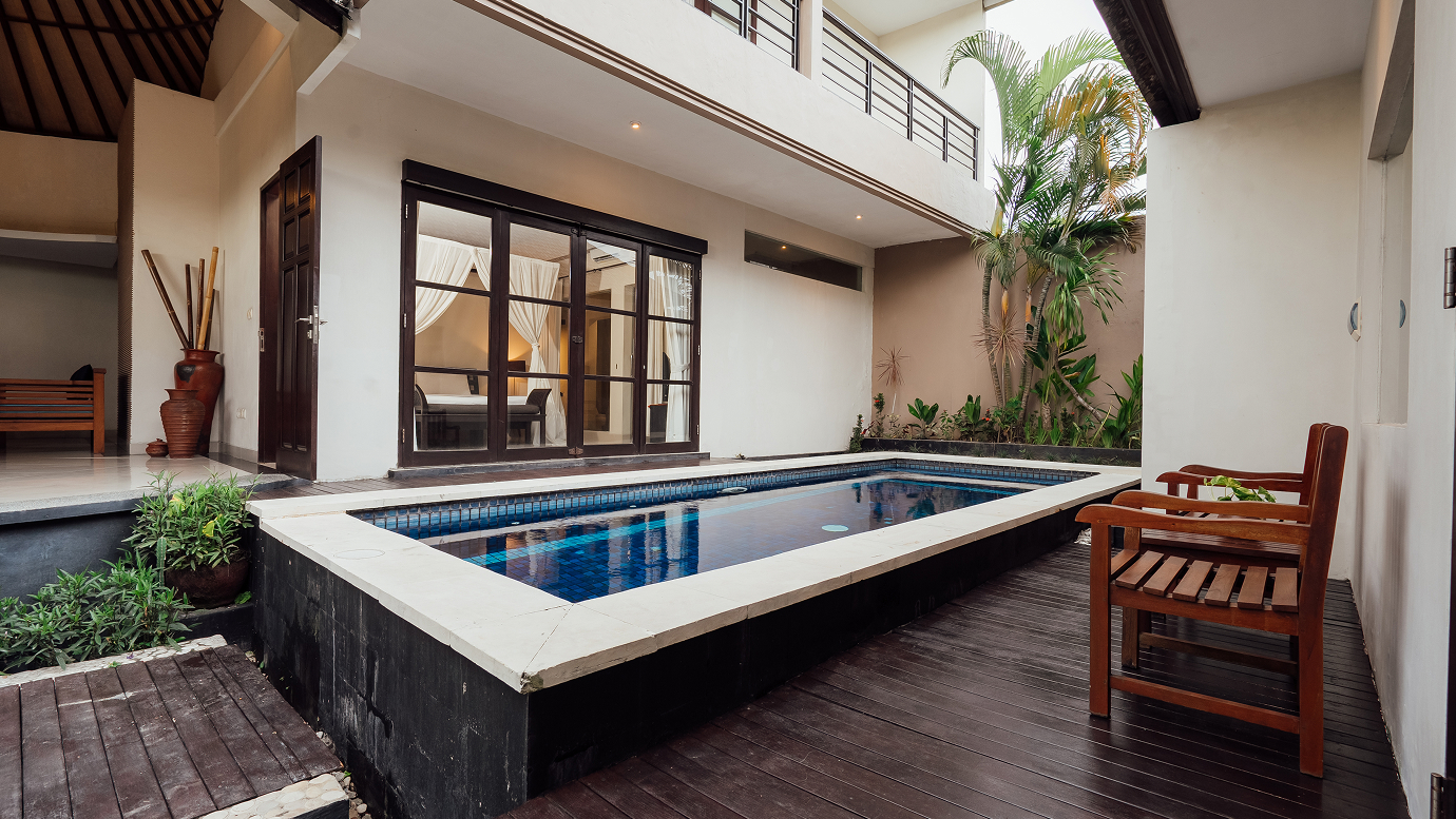 Private pool and sun loungers seen from a covered villa terrace, The Bidadari