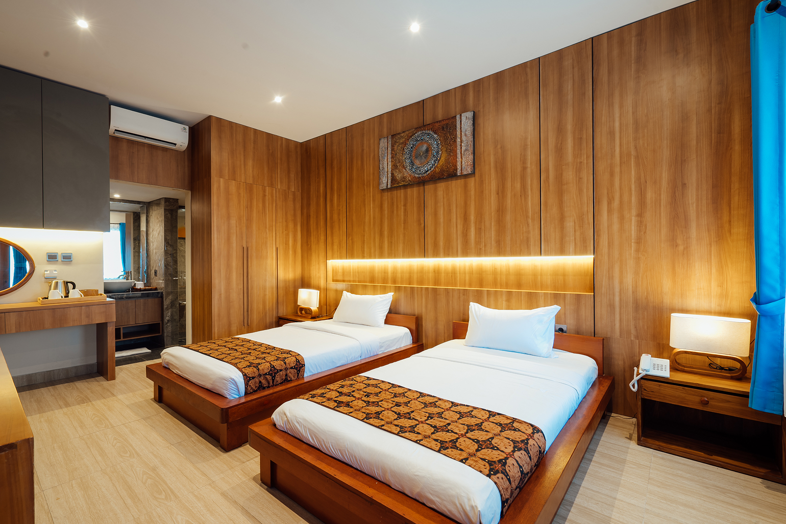 Twin-bed room with warm wood walls and headboard lighting, The Bidadari