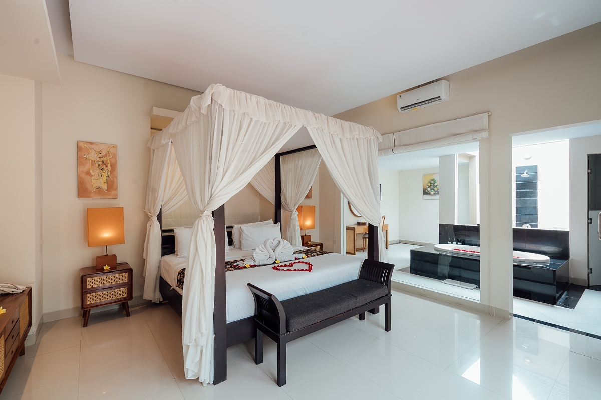 Four-poster canopy king bed with white drapes in a villa bedroom, The Bidadari