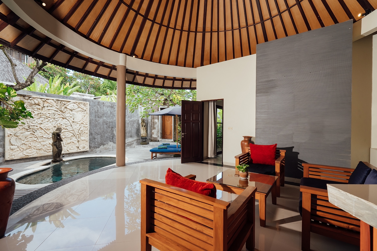 Living room with sofa and red cushions opening to the pool garden, The Bidadari