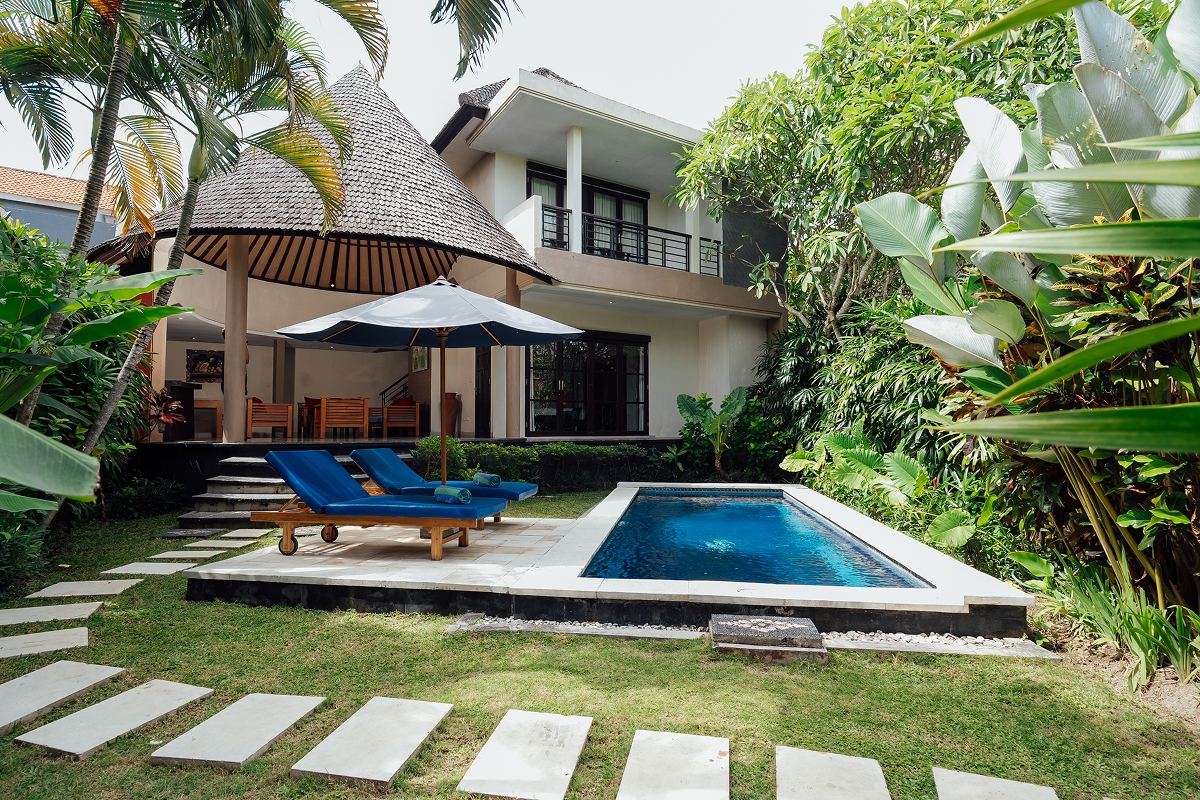 Private pool villa exterior with blue parasol and sun loungers, The Bidadari