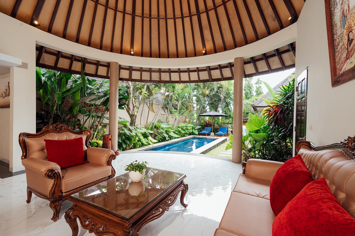 Living area with sofa and red cushions opening to the garden, The Bidadari