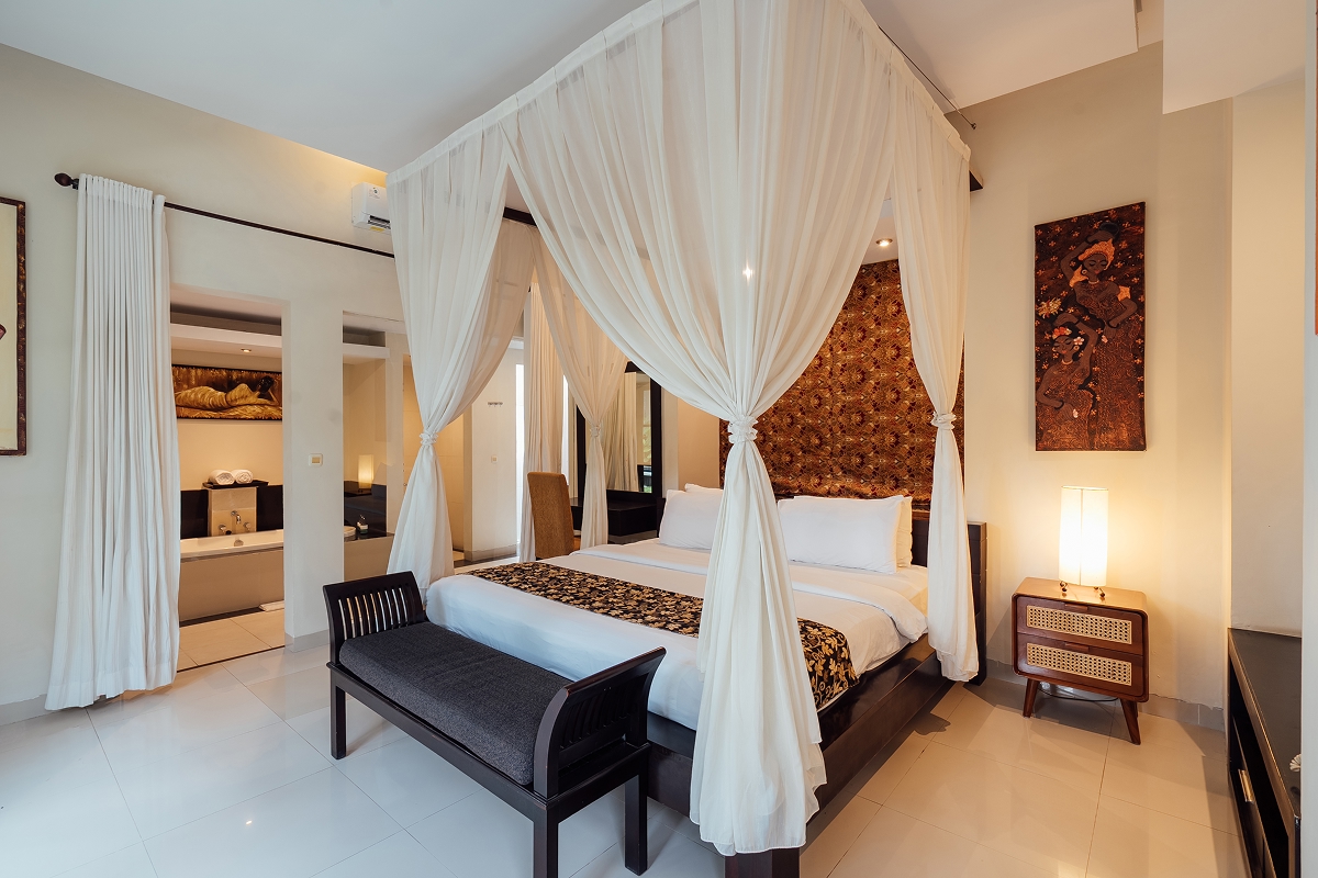 Four-poster canopy king bed by a bright window in a villa bedroom, The Bidadari