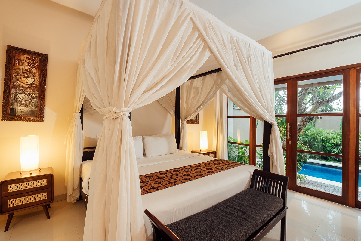 Four-poster canopy bed opening to the private pool, The Bidadari villa