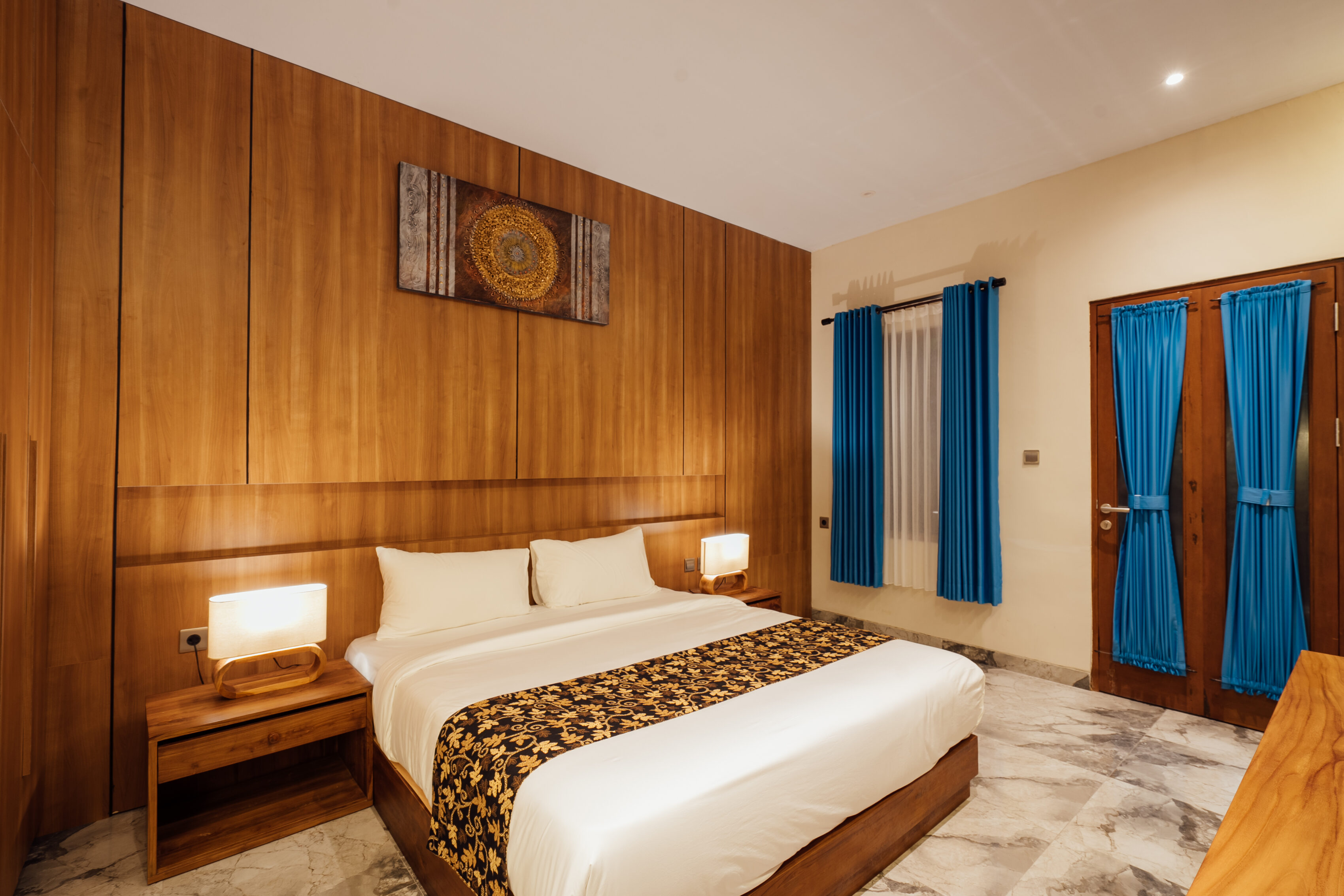 Bidadari Sanctuary Room with king bed, blue doors and wood-panelled wall