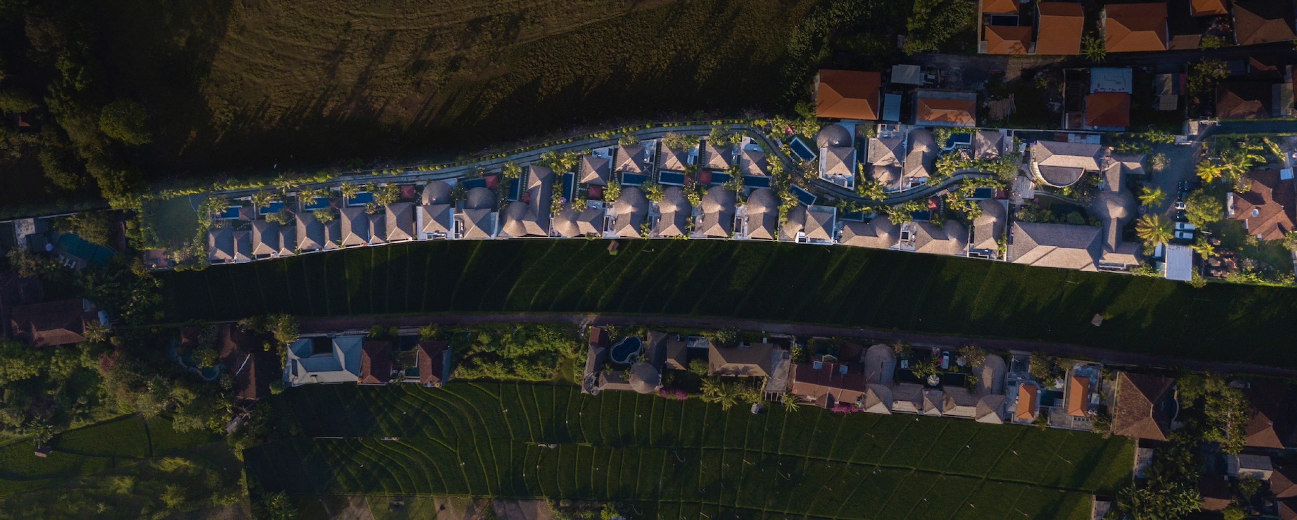 Aerial view of The Bidadari Villas & Spa at dusk, thatched-roof villas in tropical gardens, Bali
