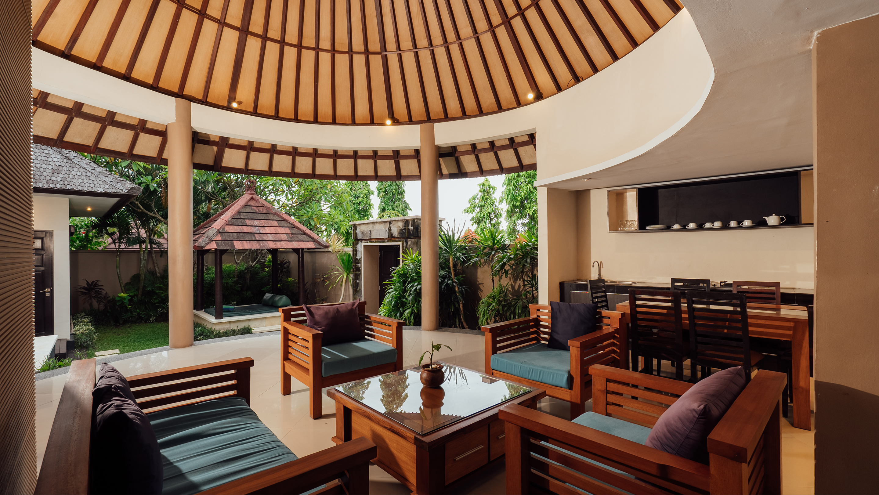 Circular thatched pavilion lounge with sofas in the garden, The Bidadari Villas & Spa