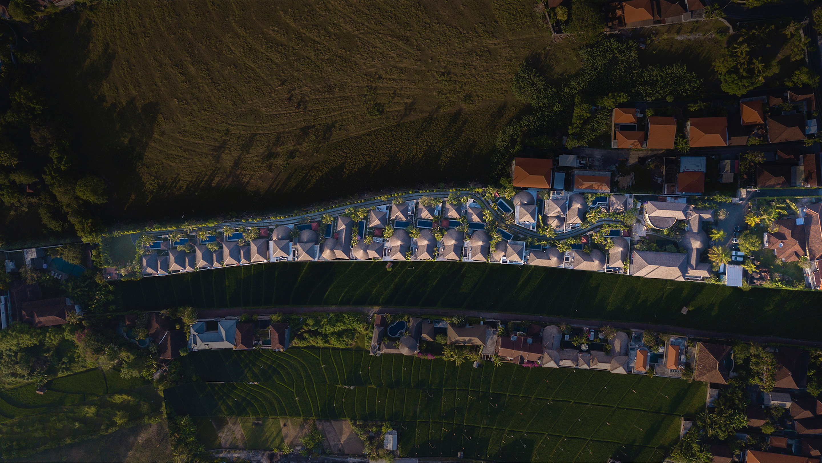 Aerial view of The Bidadari Villas & Spa at dusk, thatched-roof villas in tropical gardens, Bali