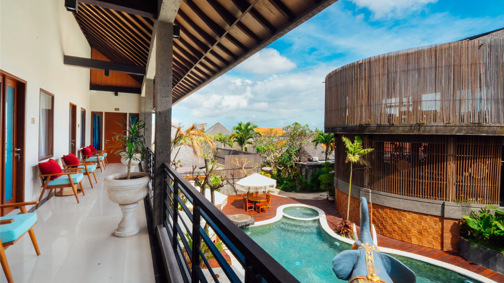 1. Tropical hotel courtyard with a swimming pool, modern architecture, and outdoor seating.